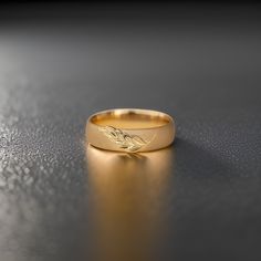 a gold wedding ring sitting on top of a table