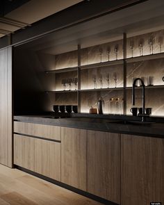 a kitchen counter with wine glasses on it and shelves in the back ground behind it