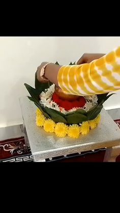 a person is decorating a cake with flowers