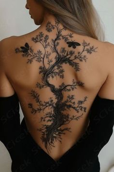 the back of a woman's body with a tree tattoo on her upper and lower back