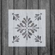 a wooden fence with a white and black tile design on the wood wall behind it