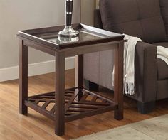 a living room with a couch, chair and end table on the hardwood flooring