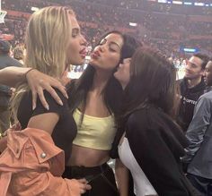 three women kissing each other at a hockey game