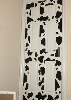 the door is decorated with black and white cow print paint on it's side