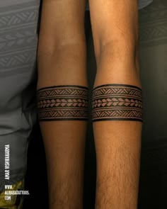 two men's legs with tattoos on them, one is black and the other is brown