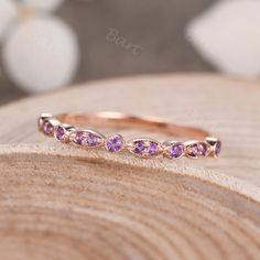 an image of a pink sapphire ring on top of a piece of wood