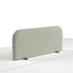 a gray couch sitting on top of a white table