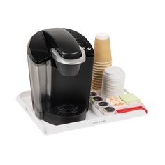 a black coffee maker sitting on top of a white tray