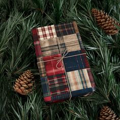 a christmas present wrapped in plaid and tied to pine cones