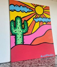 a painting of a cactus and the sun above it on a countertop in front of a white wall