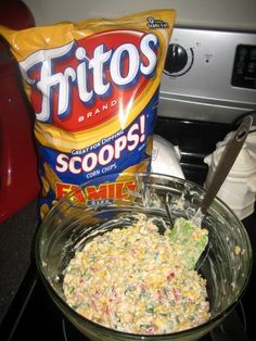 a bowl filled with food next to a bag of chips on top of a stove