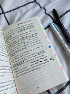 an open book with writing on it next to a pen