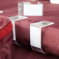 two pieces of red fabric with white tape on them, sitting next to each other