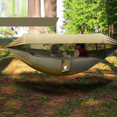 two people are sitting in a hammock