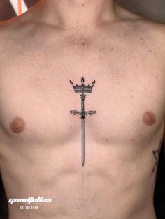 a man's chest with a cross and crown tattoo on the top of it