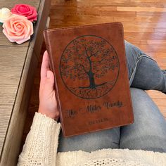 a person sitting on the floor with a book in their hand and a rose behind them