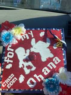 a red and white graduation cap with flowers on it