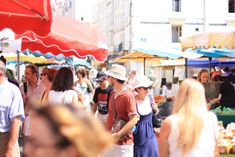 many people are shopping at an outdoor market