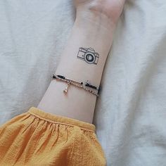 a woman's arm with a camera tattoo on it