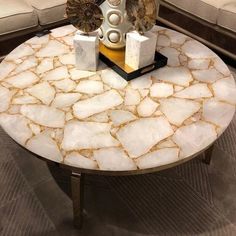 a marble coffee table sitting on top of a couch in a living room next to a chair