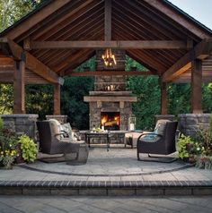 an outdoor living area with two chairs and a fire place in the middle of it