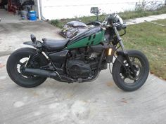 a black and green motorcycle parked in front of a house