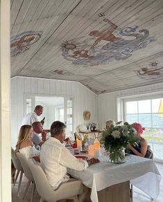 a group of people sitting around a dining room table