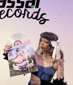 a woman holding up a record in front of her face