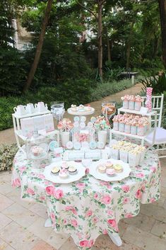 a table set up with cupcakes, cakes and desserts for a tea party