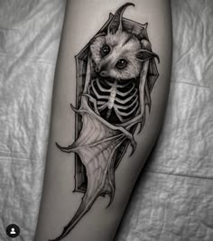 a black and white photo of a bat with a skeleton on it's leg