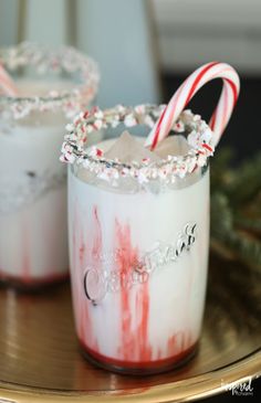 two glasses filled with liquid and candy canes