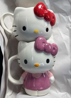 two hello kitty mugs sitting on top of each other