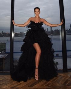 a woman in a black dress posing for the camera