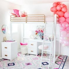 a loft bed with pink and white balloons hanging from it's sides, in a girls bedroom