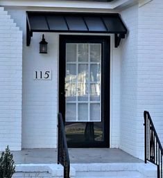 the front door of a white house with black trim