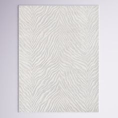 a white wall hanging on the side of a wall with a zebra print pattern in front of it