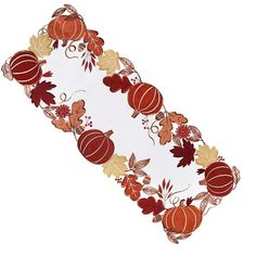 an autumn table runner with pumpkins, leaves and acorns on white background