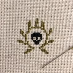 a cross stitch pattern with a skull on it