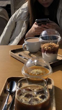 a person sitting at a table with food and a cell phone in front of them