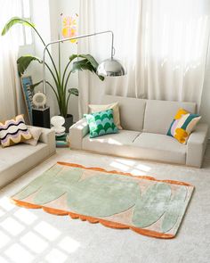 a living room with two couches and a rug on the floor in front of a window