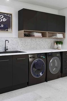 a washer and dryer in a room with black cabinets, white tile floor