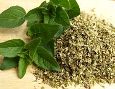 some green leaves are on top of the ground and next to it is a pile of dried