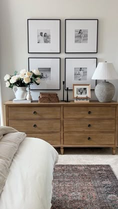 a bed room with a neatly made bed and two pictures on the wall above it