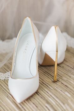 a pair of white high heels with gold detailing