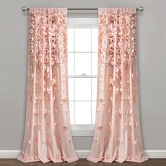 a pink curtain with flowers on it in front of a window