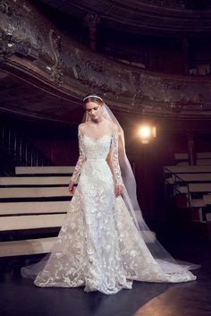 a woman in a wedding dress is standing on the stage with her veil over her head