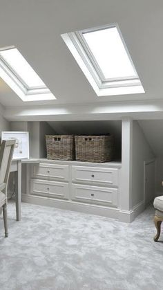 an attic bedroom with skylights and white furniture