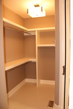 an empty walk in closet with shelves and lights