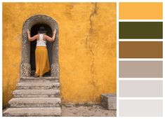 a woman standing at the entrance to a yellow building