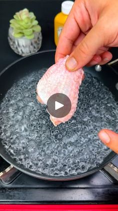 someone is cooking something in a frying pan with water on the bottom and other ingredients around it